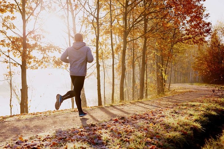 Man running in park at autumn morning. Healthy lifestyle concept