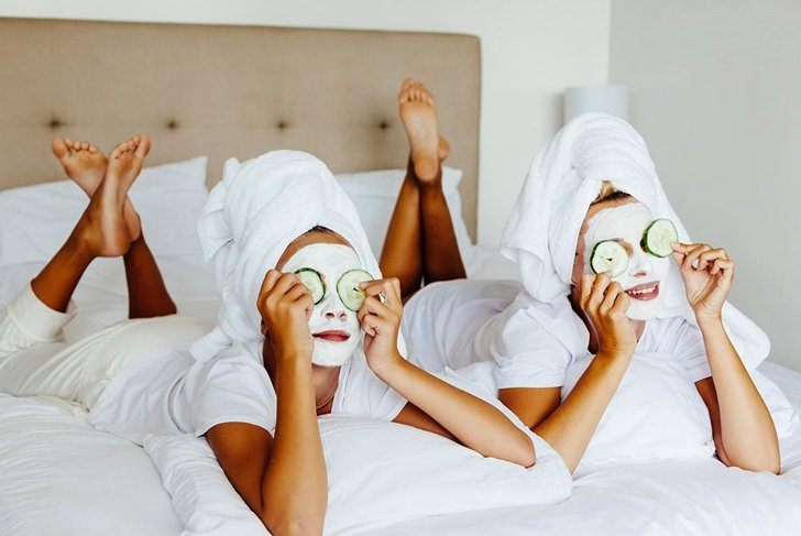 Mom and her 10 years old preteen daughter chilling in the bedroom and making clay facial mask. Mother with child doing beauty treatment together. Morning skin care routine.