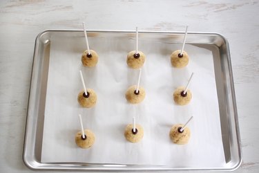 Cake pop sticks inserted into each cake ball and secured with melted chocolate