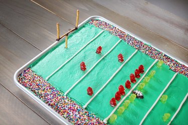Goal posts made from pretzel sticks inserted into football stadium cake