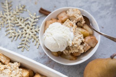 Bowl of pear cobbler with a scoop of vanilla ice cream on top