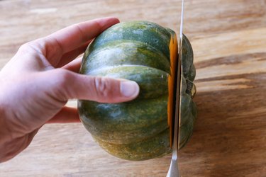 Removing the top of an acorn squash with a knife