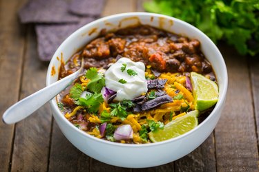 Black Bean and Pumpkin Chili topped with cilantro, tortilla chips, cheddar cheese, and sour cream.