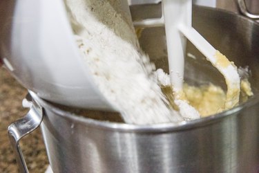 pouring flour into a mixer