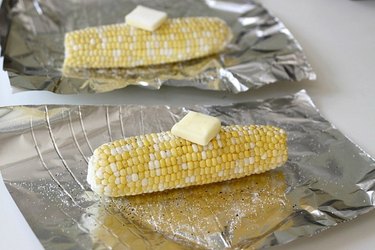 seasoned corn on the cob, on foil