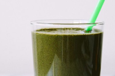 A delightfully rich, green smoothie with a green straw.