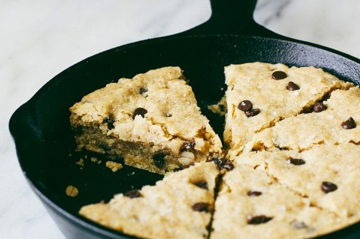 A skillet of sliced gluten-free oatmeal chocolate chip cookie.