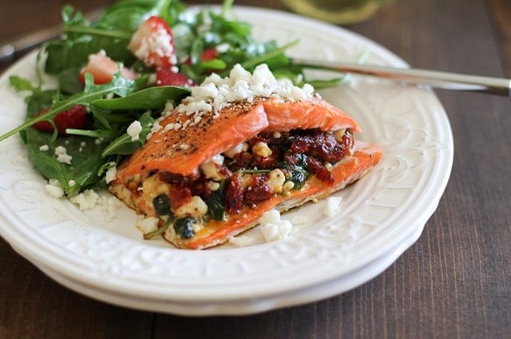 A bright and colorful dish of stuffed salmon and salad.