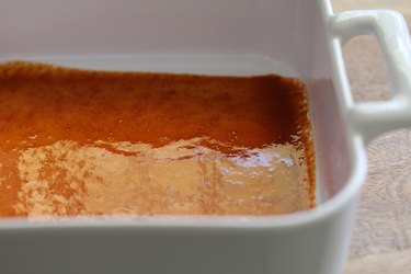 Enchilada sauce in the bottom of a casserole dish.